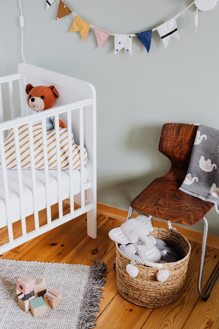 Cozy nursery interior with crib, chair, and plush toys, perfect for a baby's comfort.
